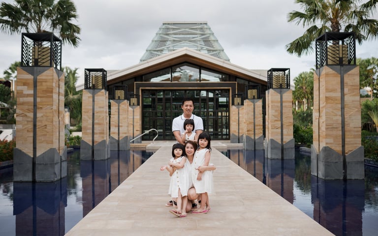 Family portrait at the iconic water reflection entrance of The Mulia Nusa Dua Bali during a Bali family photography session