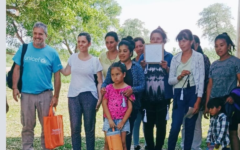 A UNICEF volunteer with a group of women and children in a community outreach program.
