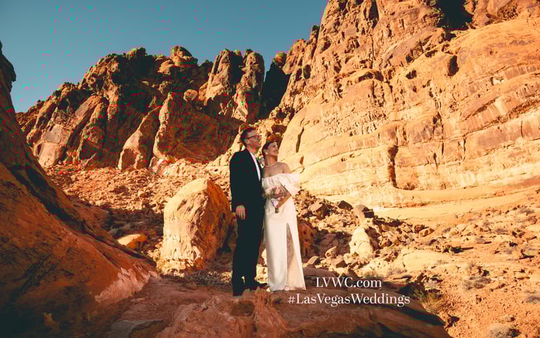 a man and woman standing on a rocky cliff