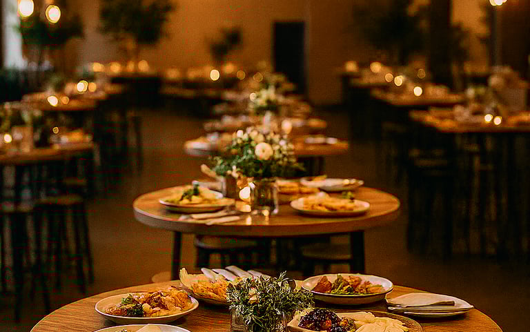 Cena de empresa con mesas altas decoradas y platos variados. Catering elegante en Málaga
