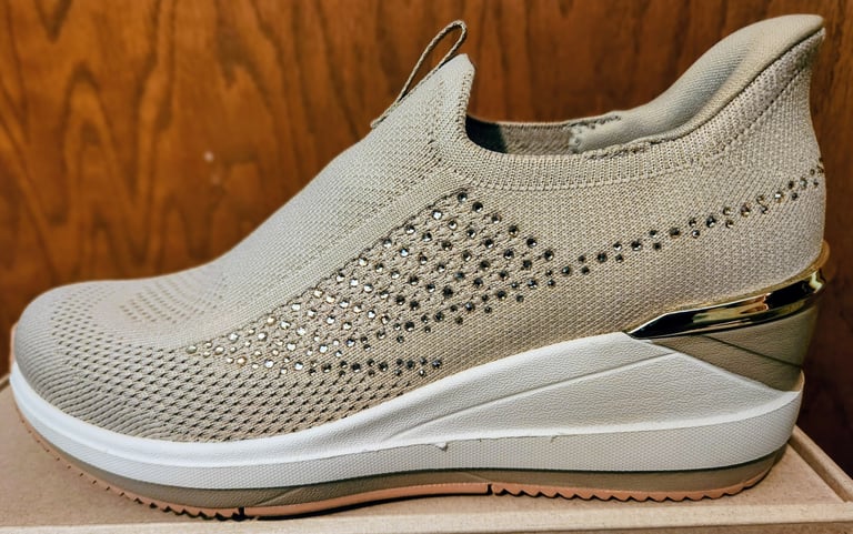 A side view of a sporty wedge shoe from Skechers
