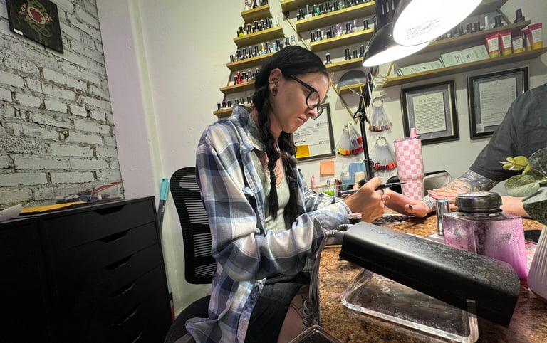 Alex doing nail art on acrylic nails in her salon booth in downtown Missoula