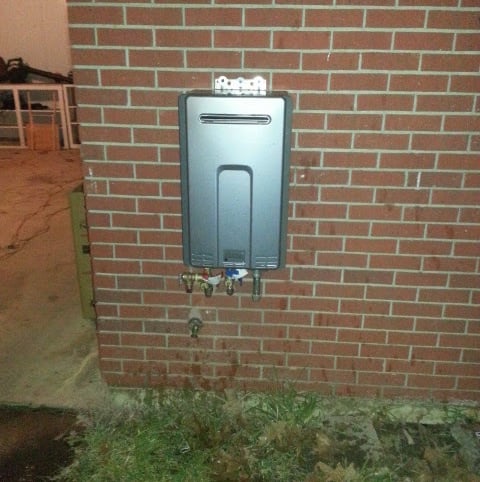 a tankless water heater on a brick wall