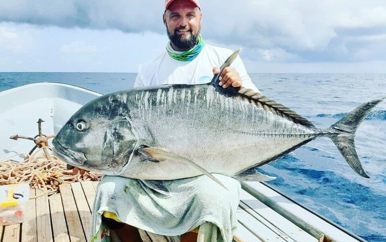 Angler holding a massive Giant Trevally on a Zanzibar fishing charter, perfect for deep-sea fishing 