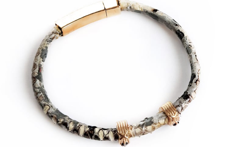 Luxury snakeskin leather bracelet with gold magnetic clasp and skull charms for men.