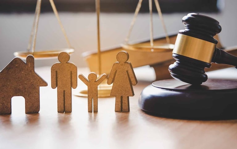 Uma escultura de família ao lado de um martelo de juiz que representam o direito de família
