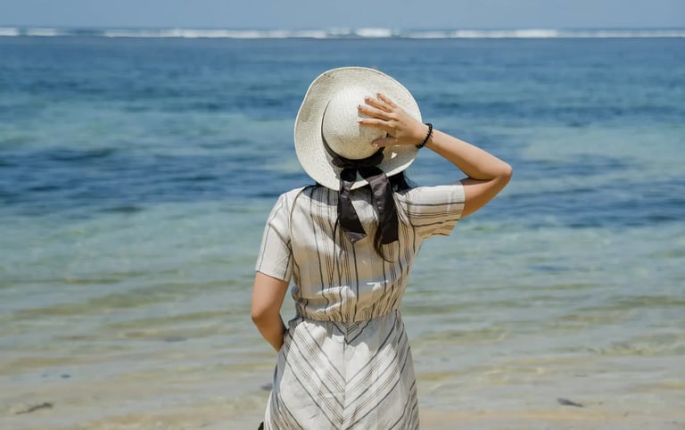 Woman walking along the shoreline during a portrait session at Samabe Bali Suites & Villas in Nusa Dua.