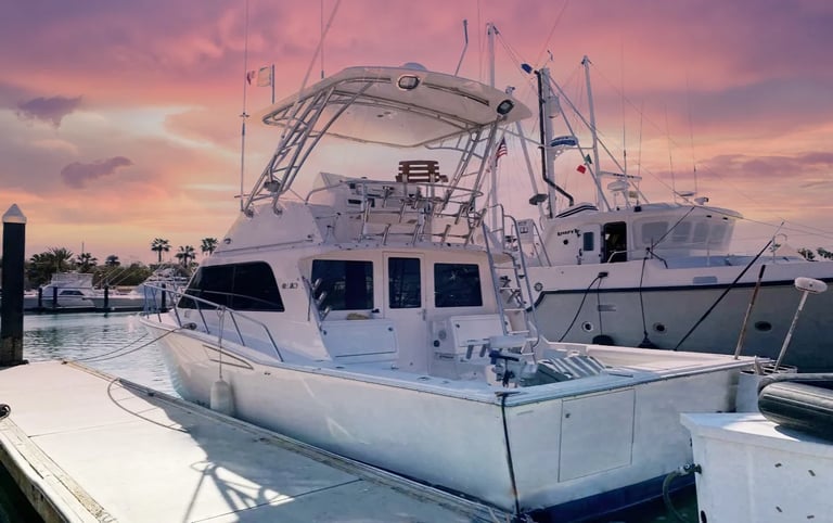 a boat docked at a dock with a pink sky
