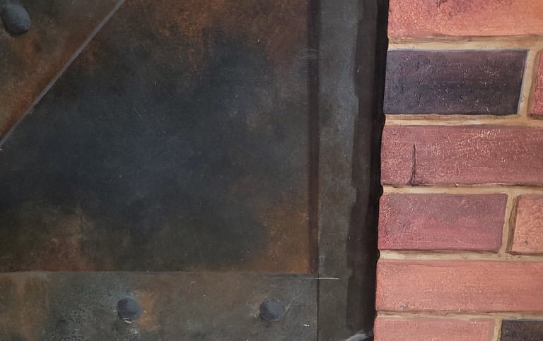 Détail d'un décor peint en trompe-l'oeil, imitation de métal rouillé et mur de briques