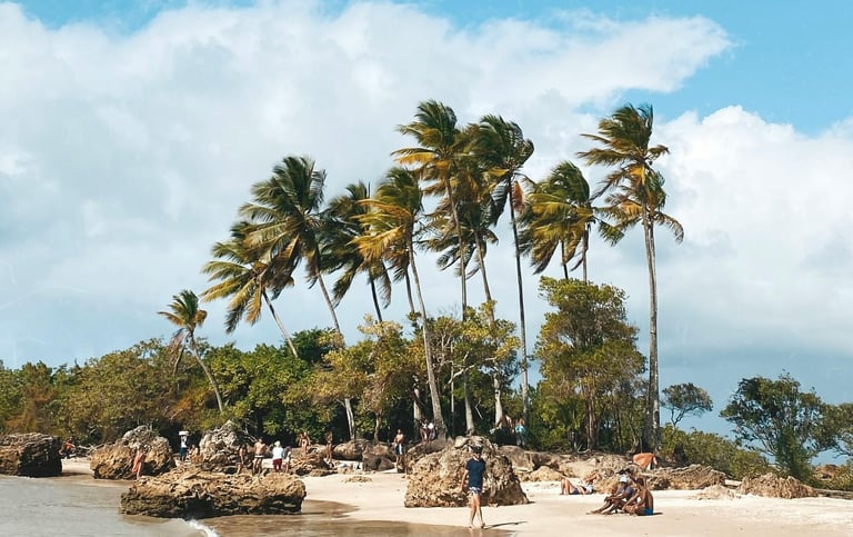 a person walking on a beach near a body of water in Morro de São Paulo, Bahia, Brazil
