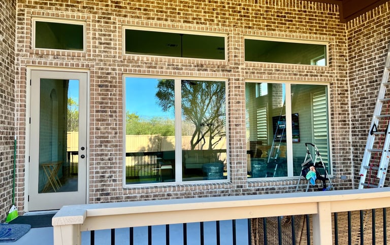 Clean reflective windows on a brick home exterior, Elegant Restorations San Antonio