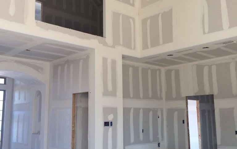 Taping jointer. Interior commercial construction work with metal ceiling structures and partitions.