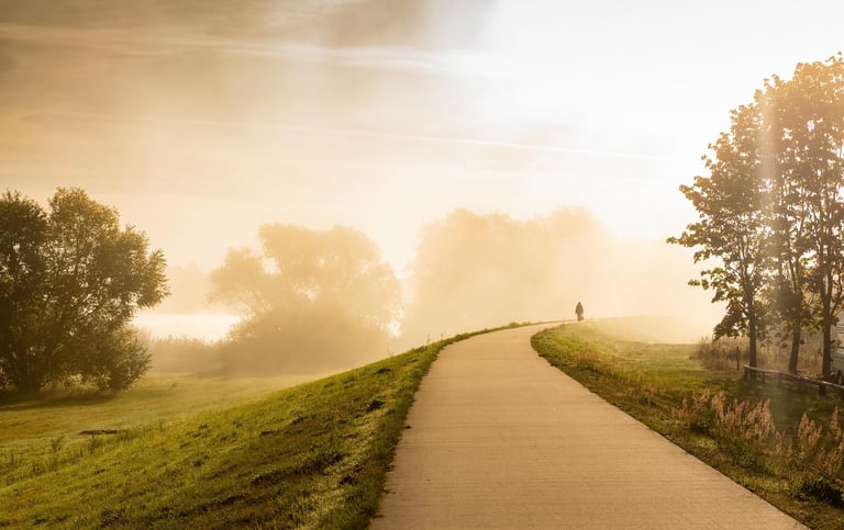 Une silhouette sur une route eclairée par le soleil du matin