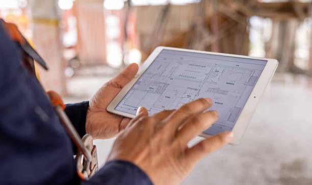 home builder looking at blueprint on tablet