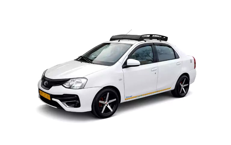 White Toyota Etios one way taxi by Saini taxi services with a luggage carrier rack