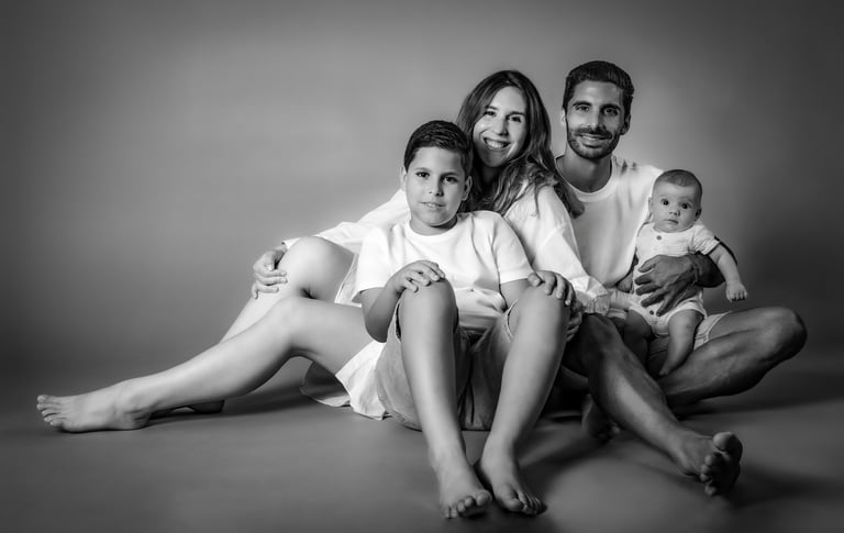 "Un retrato de familia en blanco y negro, pareja con su hijo mayor y bebé en brazos"