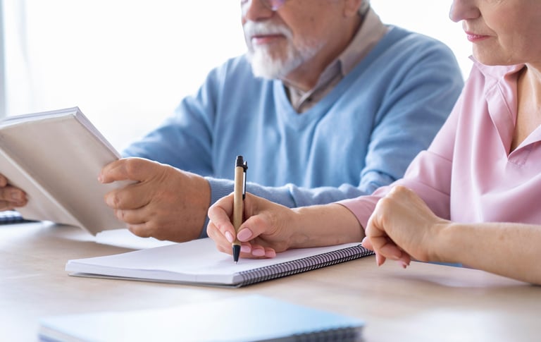 a man and woman sitting at a table with a tablet