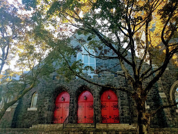 Portland, OR - An old stone church with 3 bright red doors in downtown 