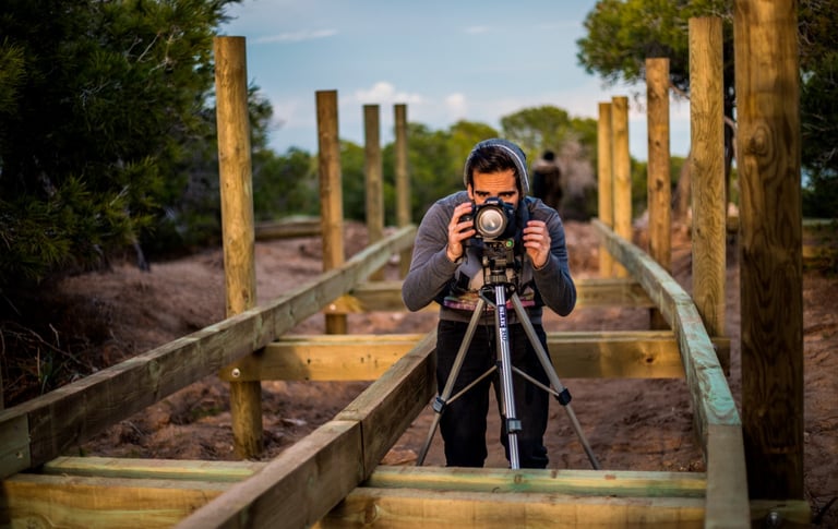un hombre tomando una fotografía en un antiguo puente de madera