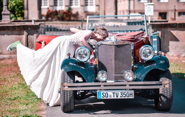 Braut mit Oldtimer – humorvolle Hochzeitsfotografie am Möhnesee.