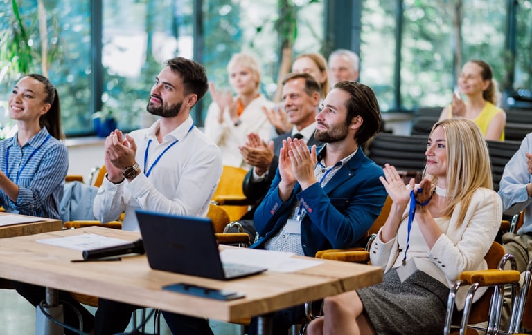 a group of people sitting at a table with laptops