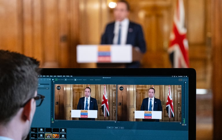 a man in a suit and tie is looking at a laptop screen