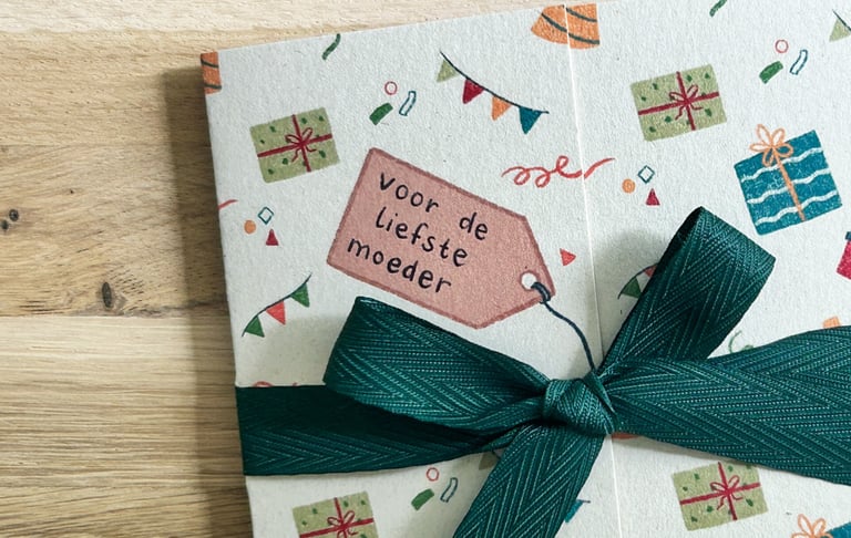 Foto van een gestrikt Kadoentje. Op de tekening van de hangtag staat 'voor de liefste moeder'.