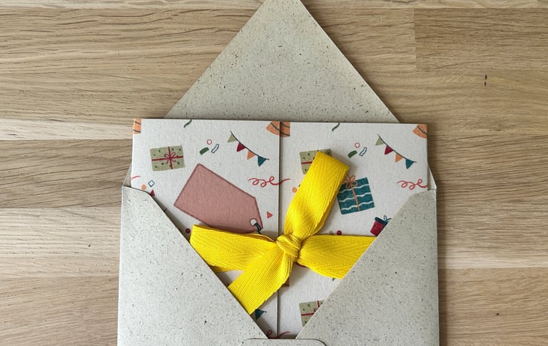 Foto van een Kadoentje met gele strik in een enveloppe