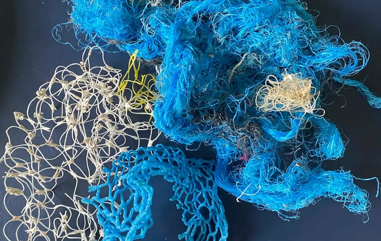 A collection of tangled blue and white plastic fishing nets and ropes representing ocean pollution.