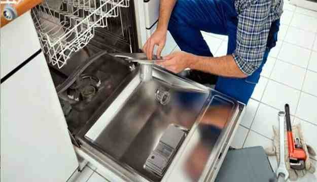 a technician cleaning the filter of a dishwasher