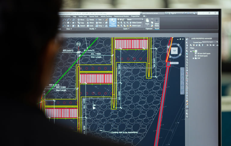 Engineer reviewing a civil engineering blueprint design on AutoCAD software display screen.