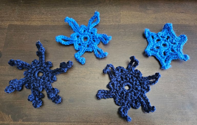 blue crochet snowflakes on a wooden table