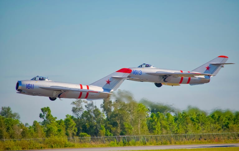 Two vintage Mikoyan-Gurevich MiG-17 fighter jets flying in close formation - Ft. Myers airshow