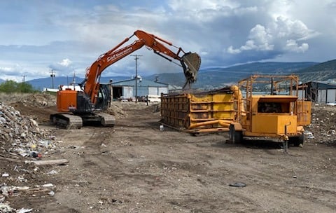 a construction site with an excavator and an incinerator