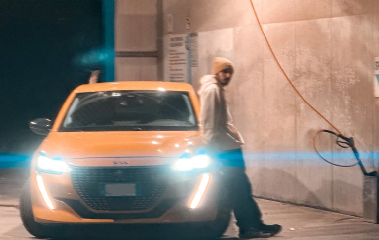 a man standing in front of a car with a light on it