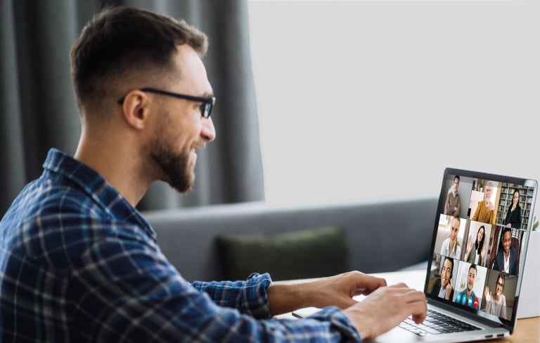 A man sitting at a table with a laptop computer