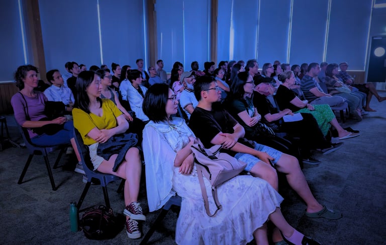 Diverse audience enjoying a cozy film screening at Auckland International Film Club.