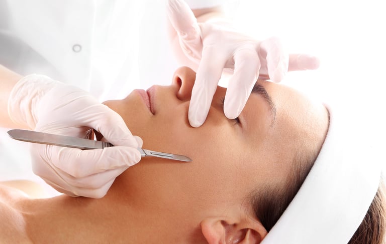 Vrouw met chirurgische handschoenen dat dode huidcellen weghaald met fijn mesje