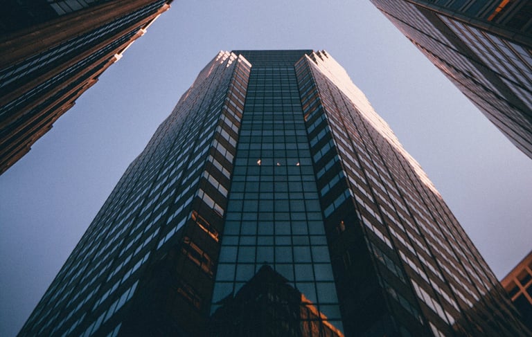 Photograph of a towering office building with blue sky above