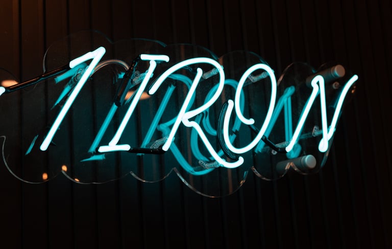 A neon 1IRON sign in an indoor golf simulator venue