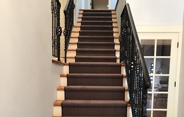 a staircase with a black and white carpet and a black stair case