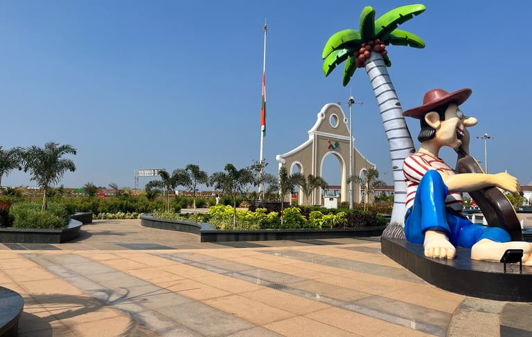 a statue of a man sitting on a bench at mopa airport entrance