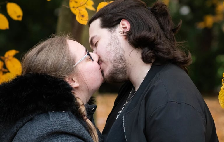 Deux amoureux s'embrassant sous les feuilles jaunes de l'automne