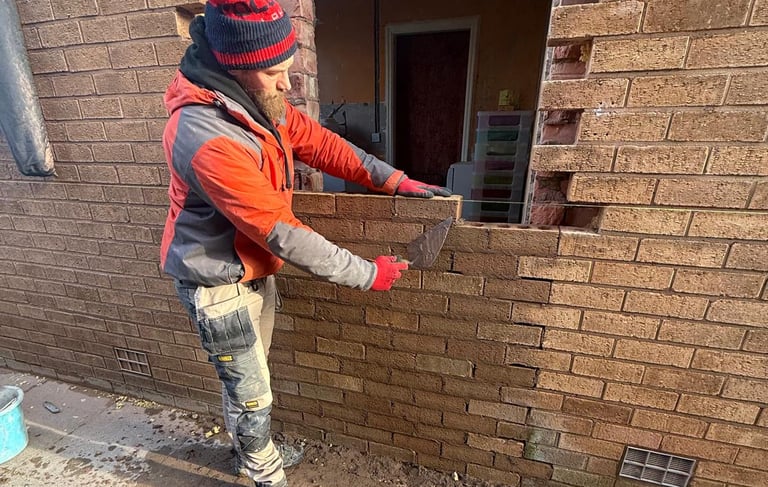 Bricklayer repairing brickwork on residential property in Southport