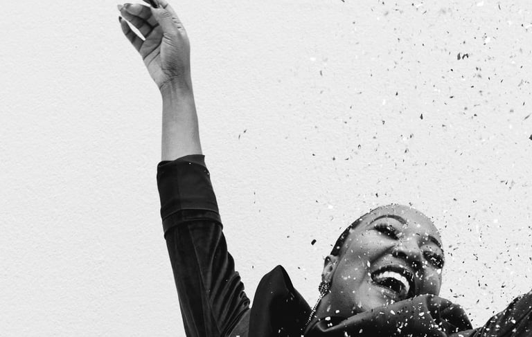 a woman in a black dress celebrating with confetti, black and white