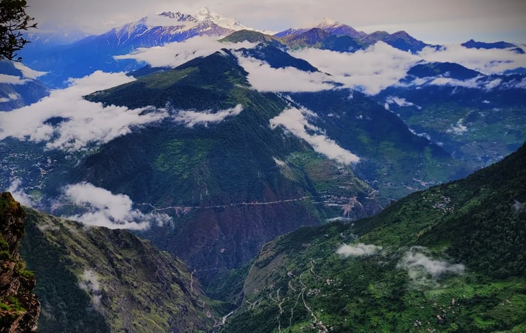 Mountain ridges with clouds and distant snowy peaks
