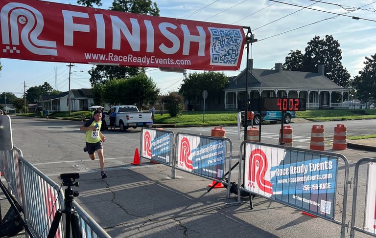 A young runner races through the finish line of a 5 Mile race in only 40 minutes, 2 seconds