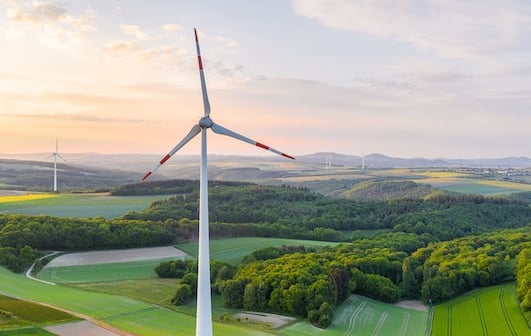 Windrad in grüner Landschaft