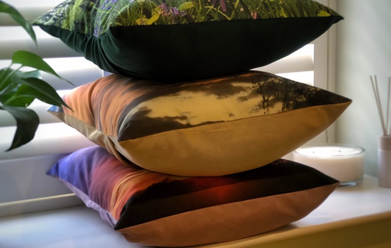 A cushion stack of 3 pillows with nature photography prints and soft touch velvet or faux suede back