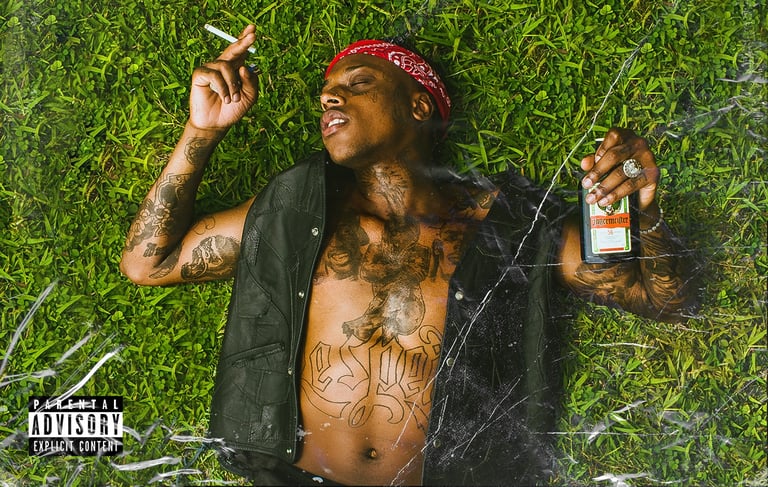 a man with tattoos on his chest and a cigarette